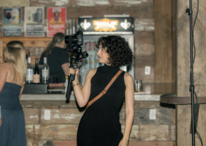 Female Videographer films holding a gimbal.
