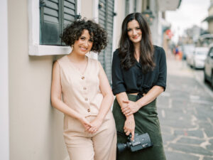Two female wedding videographers in new orleans holding a video camera.
