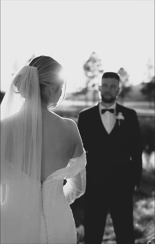 Bride in a wedding dress looking over her shoulder at the groom.
